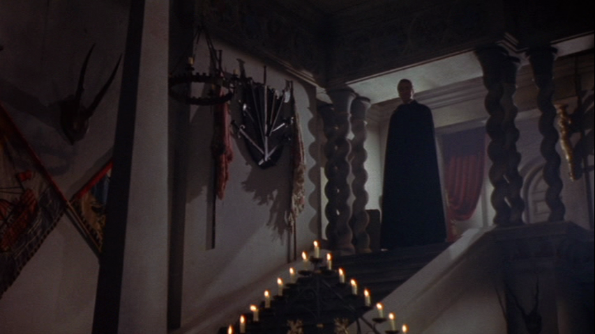 Dracula cuts an ominus silhouette from the top of the staircase. The use of light and shadows create an iconic image that pays tribute to earlier expressionist influences.