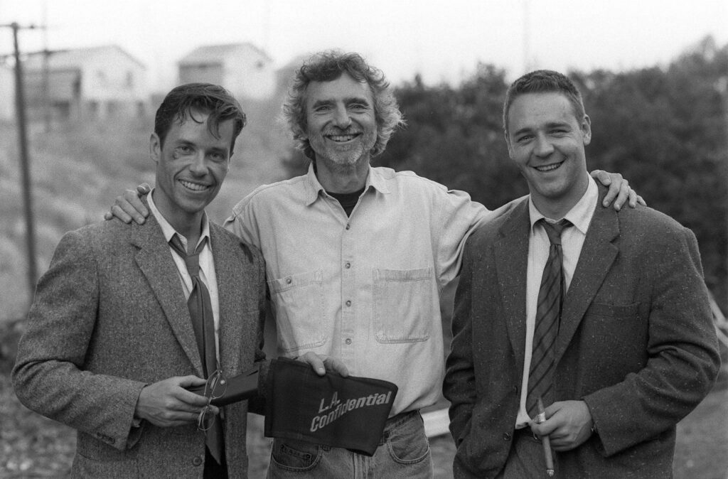 Guy Pierce, Curtis Hanson and Russell Crowe during the filming of LA Confidential (1997)