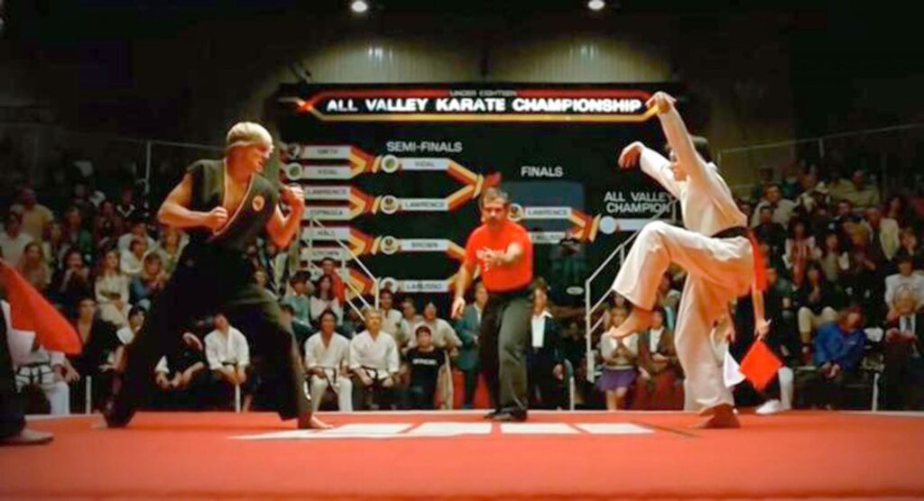 Johnny Lawrence (William Zabka) of Cobra Kai and Daniel LaRusso (Ralph Macchio) of Miyagi-do face off in The Karate Kid (1984)