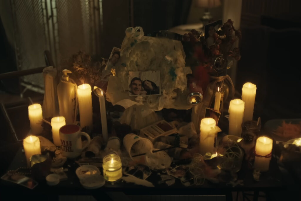A candle-lit shrine in Obsession (2025)