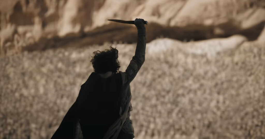 Paul Atreides holds a dagger aloft in Dune Part Two (2024)